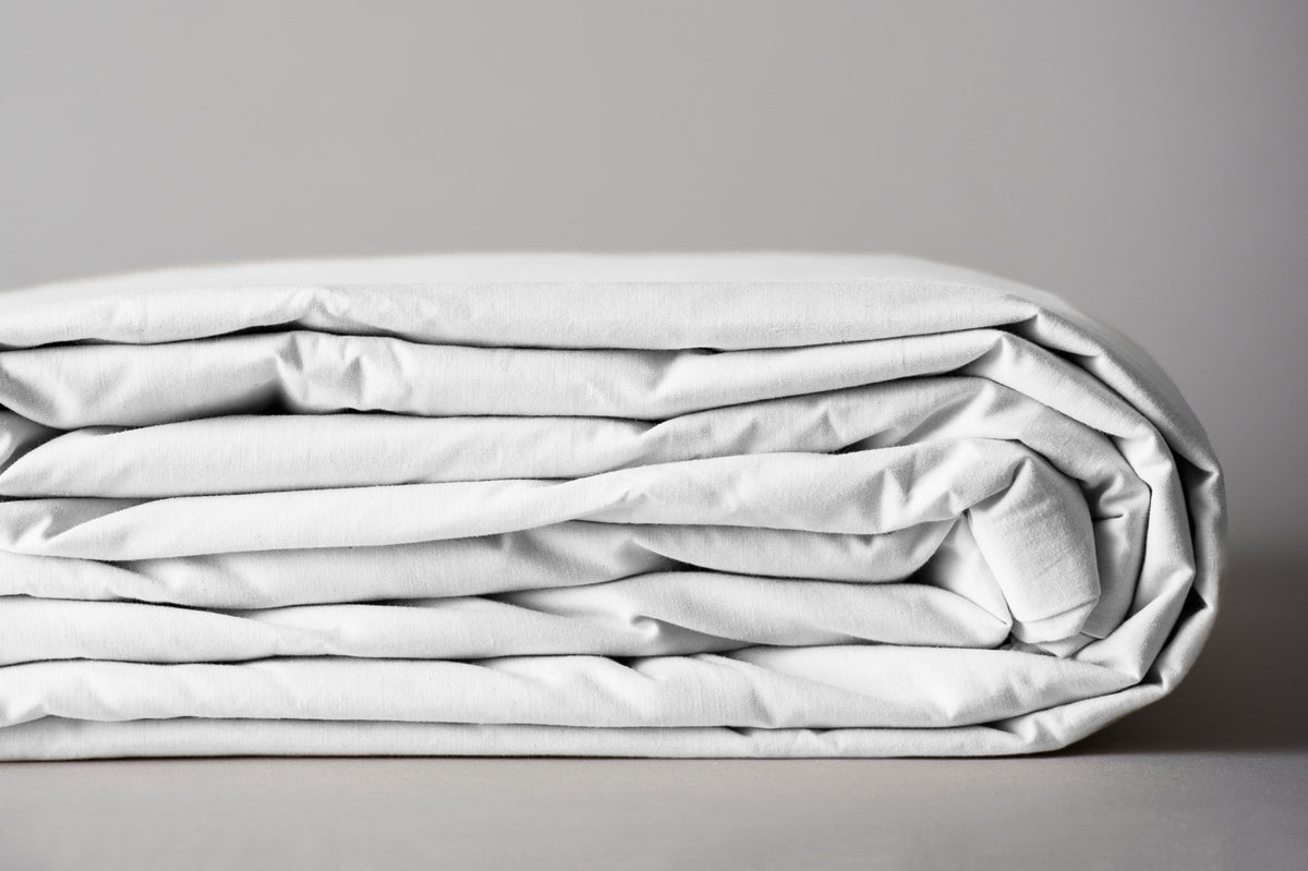 White organic cotton duvet cover folded for storage.