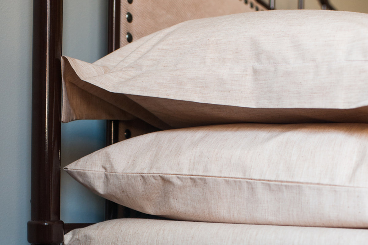 2 Organic Pillowcases with Pillows stacked on a side table
