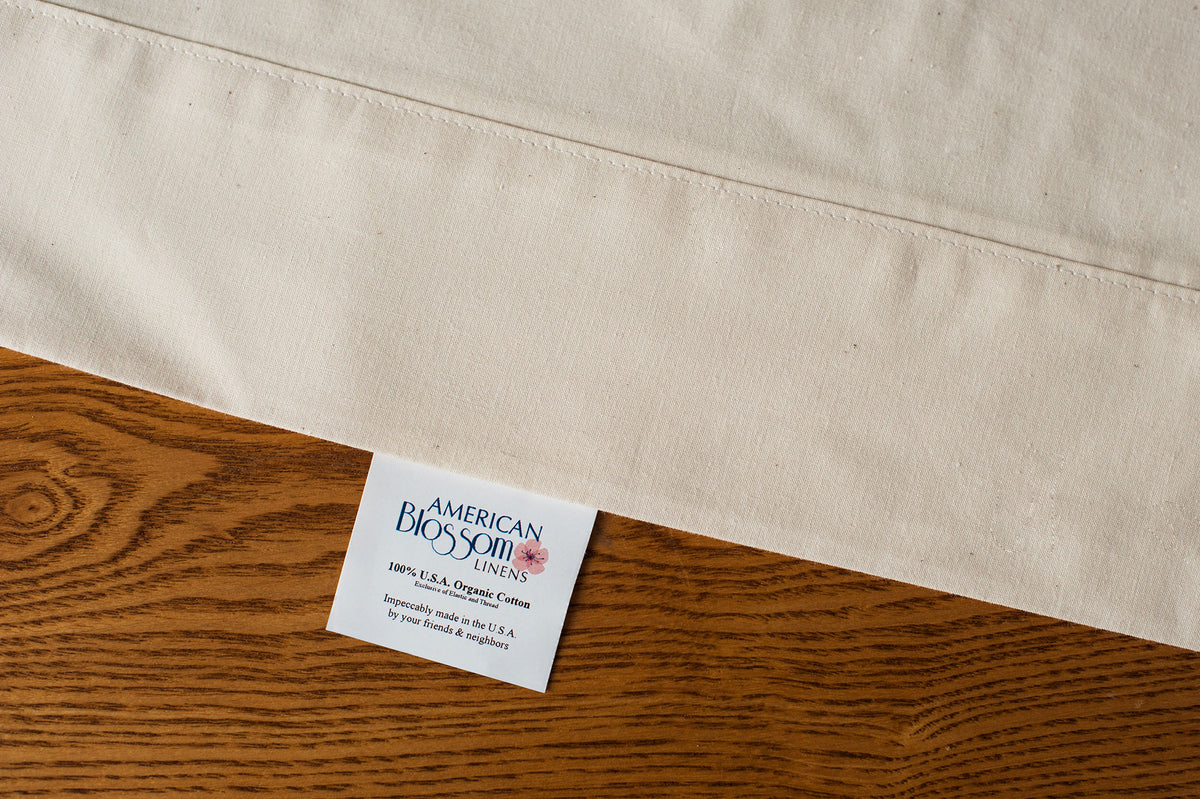 Organic cotton pillowcases in natural color showing pillowcase tag.
