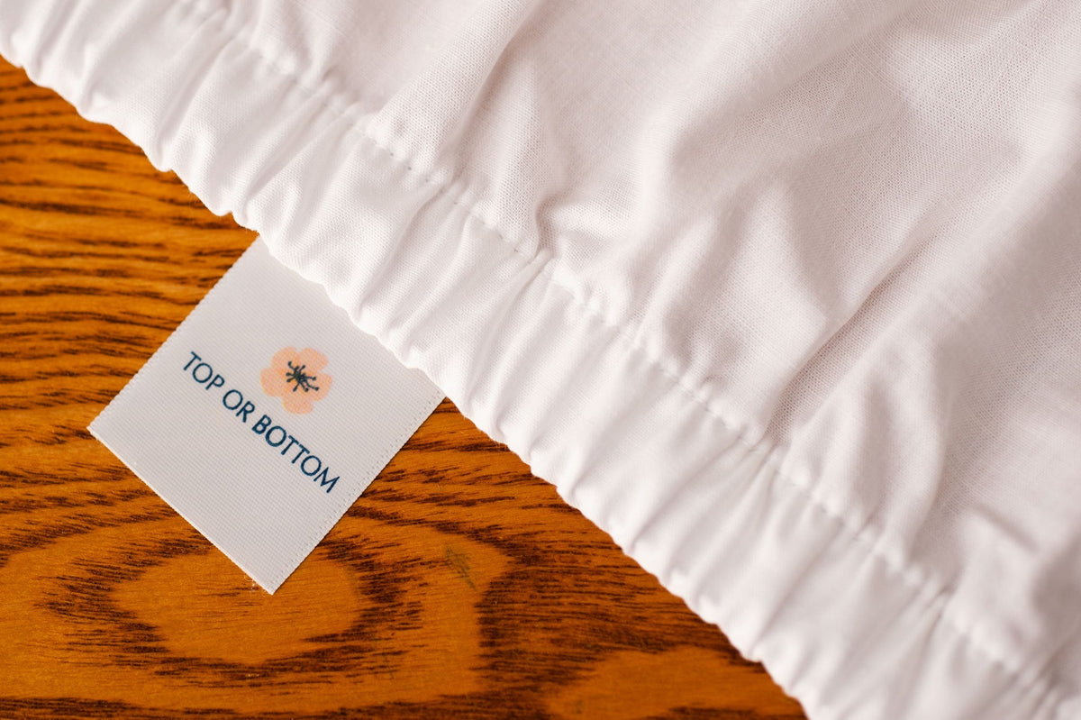 Fitted organic cotton sheet showing american blossom linens tag.
